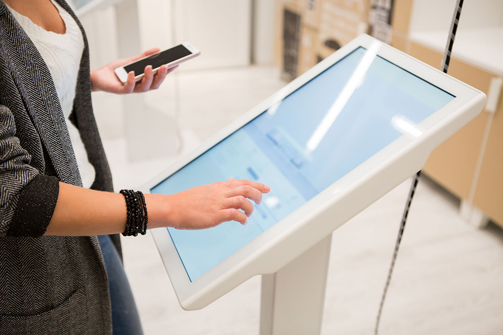 image of woman interacting with a touchscreen monitor